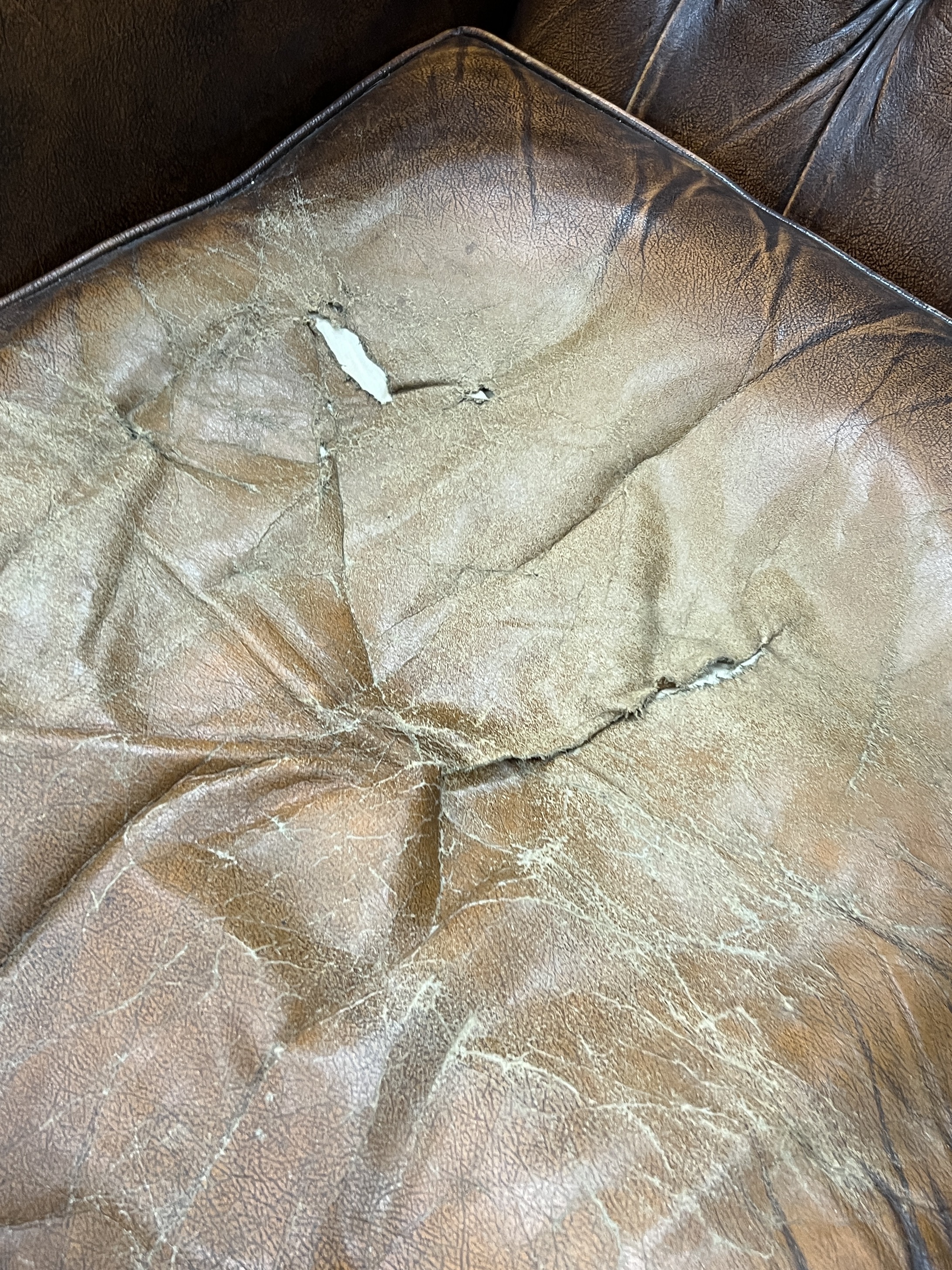 A Victorian style buttoned leather armchair, width 85cm, depth 76cm, height 106cm and a stool